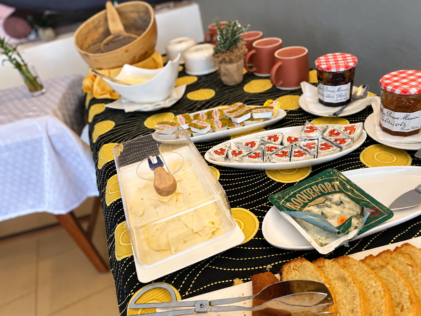 Le buffet réel du petit-déjeuner de l’Hôtel Dior, avec pains, fromages, confitures et tasses