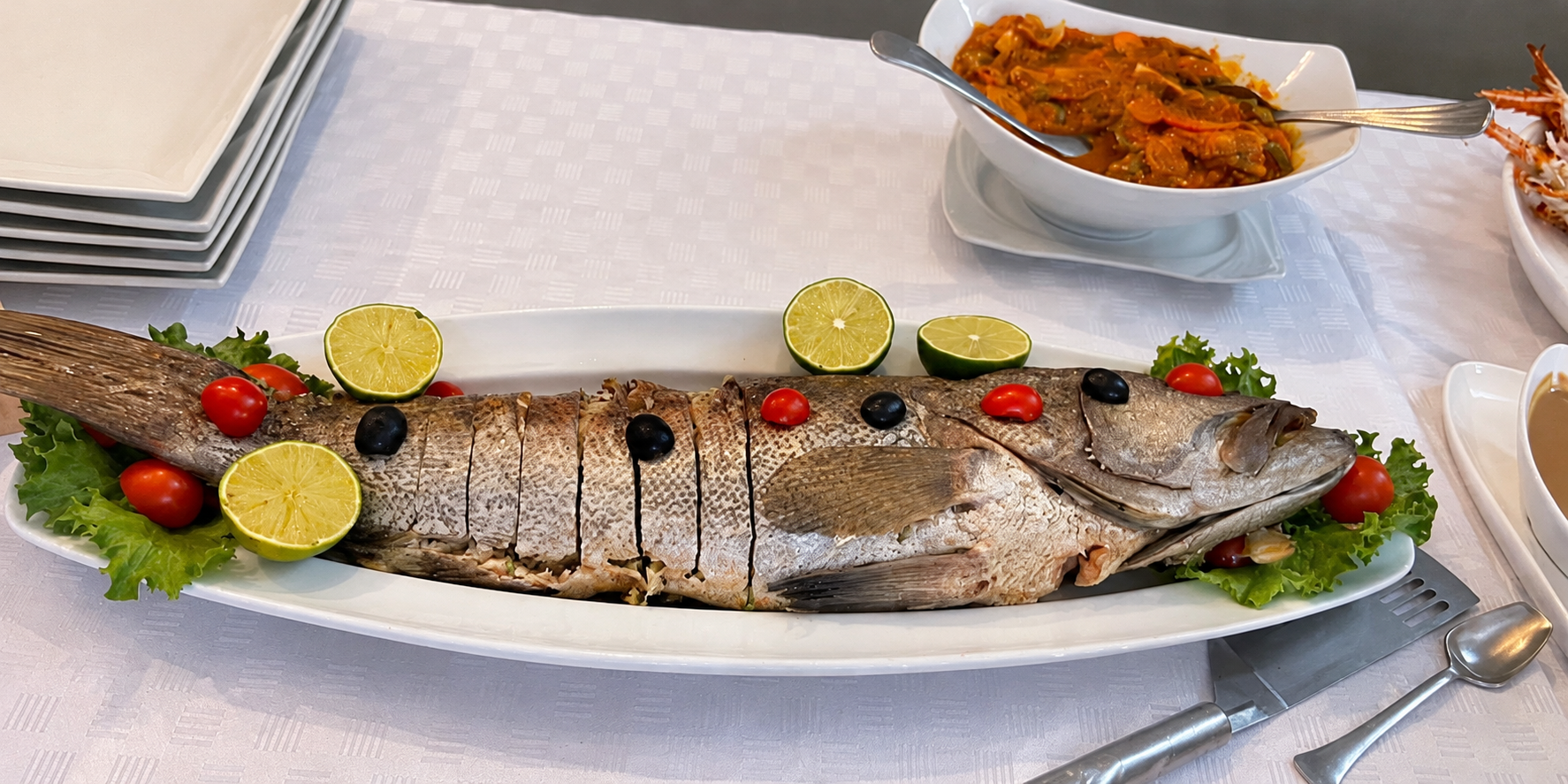 Un poisson entier présenté sur un grand plat au restaurant de l’Hôtel Dior